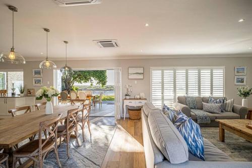 a living room with a table and a couch at The River House - Addo Elephant Park in Gqeberha