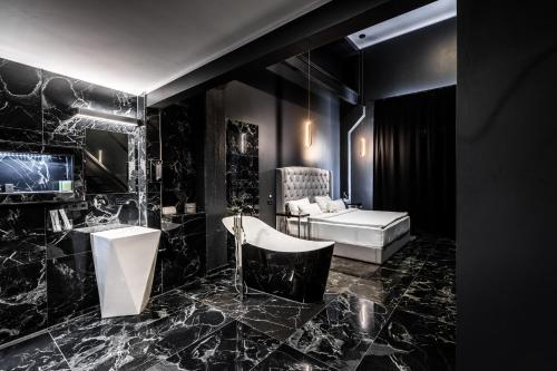 a black bathroom with a sink and a tub at Black Hotels Köln in Cologne
