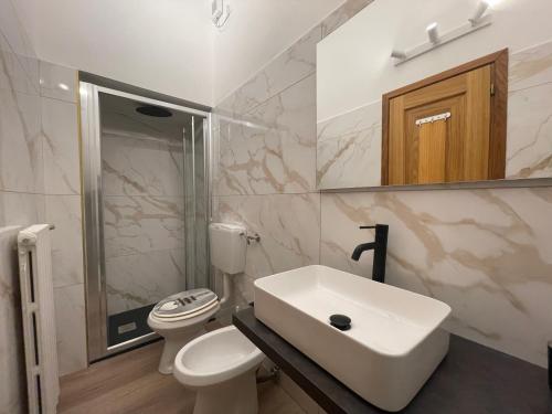 een witte badkamer met een wastafel en een toilet bij Les Tres Chic in Cesena