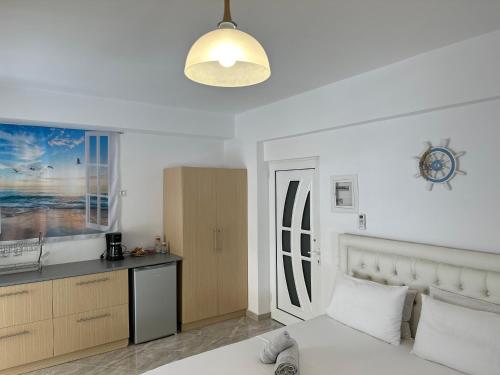 une chambre blanche avec un lit et une cuisine dans l'établissement Kejsi Studios, à Ksamil