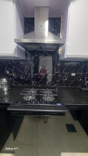 a kitchen with a stove top with a hood at Eamar tower 2 in Tanta