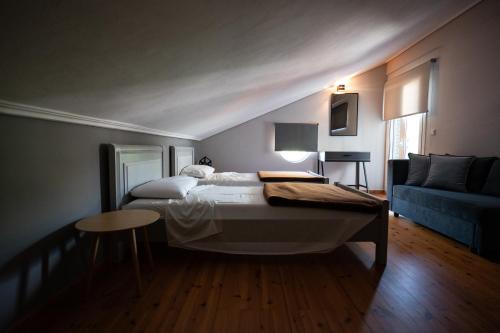 sypialnia z łóżkiem i niebieską kanapą w obiekcie Kaiafas Lake Hotel w mieście Kaiafas