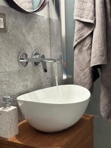 a white bowl sink sitting on a wooden table in a bathroom at La Grotta dell'Orso in Aosta