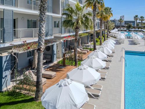 a row of white umbrellas next to a swimming pool at Barut GOIA in Side