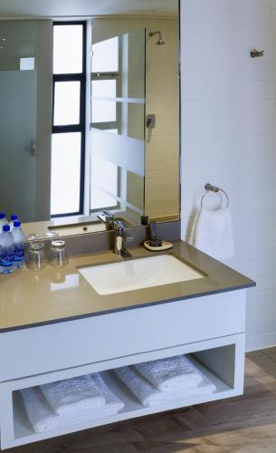 a bathroom with a sink and a mirror at Royal St. Andrews Hotel, Spa and Conference Centre in Port Alfred
