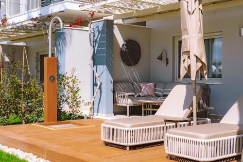 a patio with white chairs and an umbrella at Barut GOIA in Side