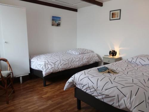 - une chambre avec 2 lits et une chaise dans l'établissement Holiday Home Ti an Naod by Interhome, à Plouescat