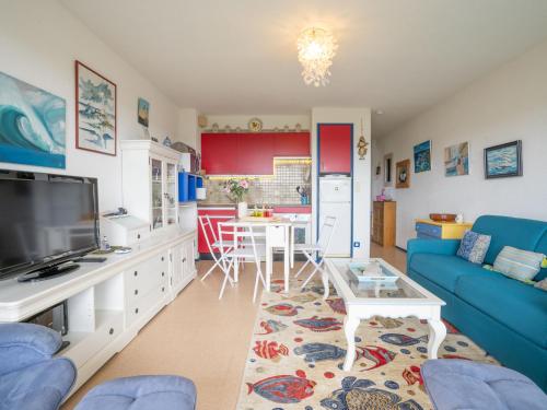 ein Wohnzimmer mit einem blauen Sofa und einem Tisch in der Unterkunft Apartment Plein Sud-1 by Interhome in Quiberon
