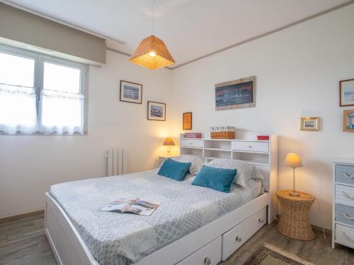 une chambre avec un grand lit avec des oreillers bleus dans l'établissement Apartment Plein Sud-1 by Interhome, à Quiberon