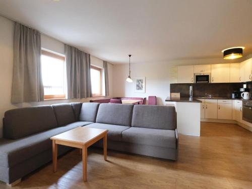a living room with a gray couch and a kitchen at Apartment Edith-1 by Interhome in Imst
