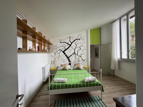 a room with a bed with a tree mural on the wall at Villa Rossini in Tavernerio