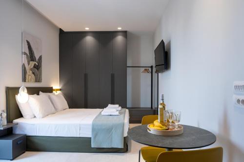 a bedroom with a bed and a table and chairs at Mosaic Urban Living in Heraklio Town