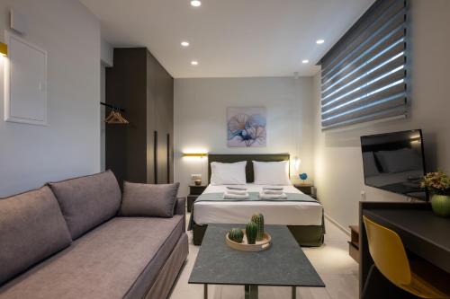 a hotel room with a bed and a couch at Mosaic Urban Living in Heraklio