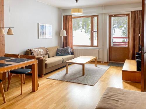 uma sala de estar com um sofá e uma mesa em Holiday Home Ylläs chalets a307 by Interhome em Ylläs