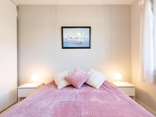 a bedroom with a pink bed with two lamps at Apartment Les Pêcheurs-4 by Interhome in Mimizan-Plage