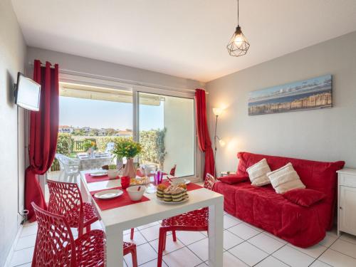 un salon avec un canapé rouge et une table dans l'établissement Apartment Les Pêcheurs-4 by Interhome, à Mimizan-Plage