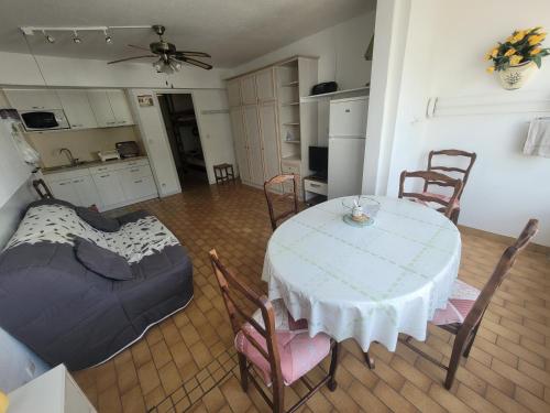 eine Küche und ein Esszimmer mit einem Tisch und Stühlen in der Unterkunft Studio cabine au centre ville à 150m de la plage N1 66 in La Grande-Motte