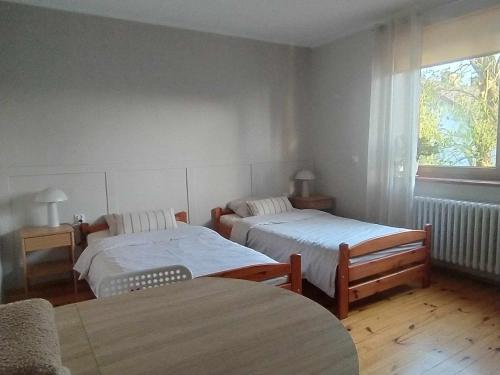 a bedroom with two beds and a window at Pokoje gościnne u Doroty in Kazimierz Dolny