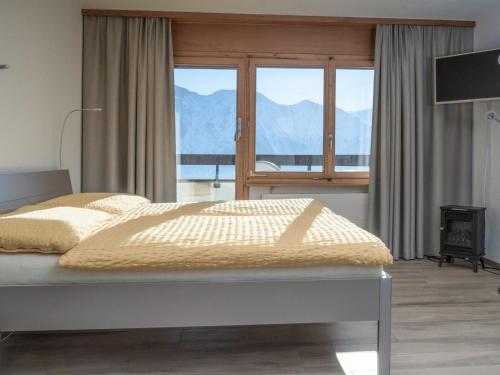 a bedroom with a bed with a view of mountains at Apartment Appartementhaus Zurschmitten 15 by Interhome in Riederalp