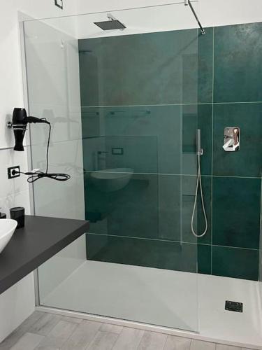 uma cabina de duche em vidro na casa de banho com um lavatório em Nonna Gina House em Tortolì