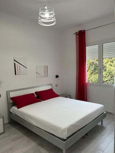 um quarto com uma cama grande e almofadas vermelhas em Nonna Gina House em Tortolì
