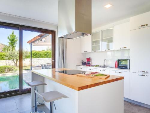 a kitchen with white cabinets and a counter with a table at Villa Luna Nera by Interhome in Sveti Petar u Šumi