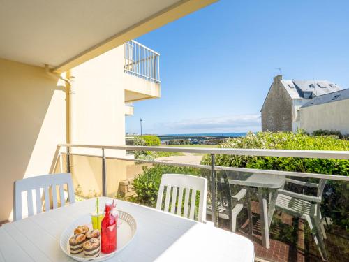 une table avec une assiette de nourriture sur un balcon dans l'établissement Studio Les Terrasses Port Maria-1 by Interhome, à Kervoz