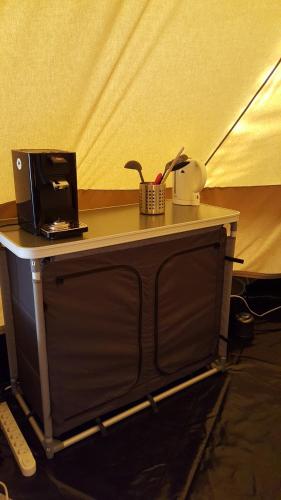 a table with a microwave and a coffee maker on it at Tent-Ok Westerbeek in Westerbeek