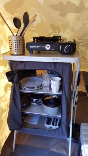 a table with a radio and utensils on it at Tent-Ok Westerbeek in Westerbeek