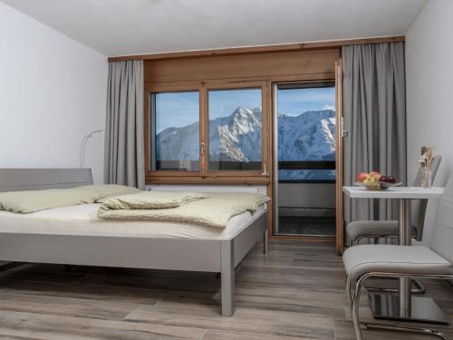 a bedroom with a bed and a view of mountains at Apartment Appartementhaus Zurschmitten 16 by Interhome in Riederalp