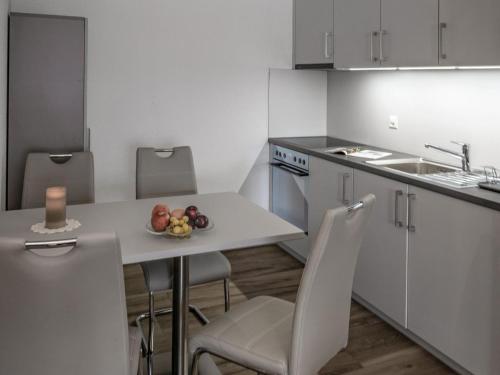 een keuken met een tafel en een fruitschaal bij Apartment Appartementhaus Zurschmitten 16 by Interhome in Riederalp