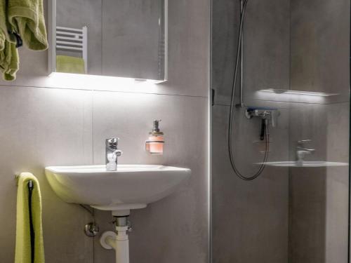 een badkamer met een wastafel en een douche met een spiegel bij Apartment Appartementhaus Zurschmitten 16 by Interhome in Riederalp