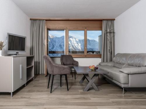 een woonkamer met een bank en een tafel bij Apartment Appartementhaus Zurschmitten 16 by Interhome in Riederalp