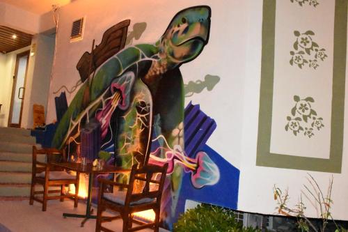 a mural on the wall of a room with chairs at Caretta Caretta Hotel in Dalyan