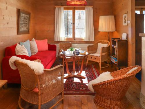 ein Wohnzimmer mit einem Sofa, Stühlen und einem Tisch in der Unterkunft Apartment Chalet Ahorni by Interhome in Hornkessel