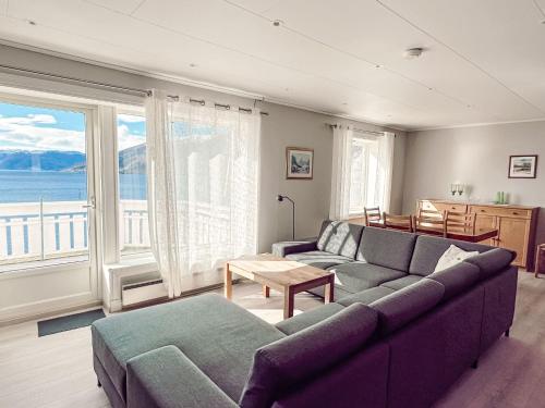 a living room with a couch and a large window at Holiday Home Tantestova - FJS296 by Interhome in Balestrand