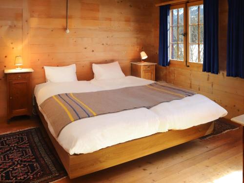 a bedroom with a large bed in a wooden room at Apartment Chalet Ahorni by Interhome in Hornkessel