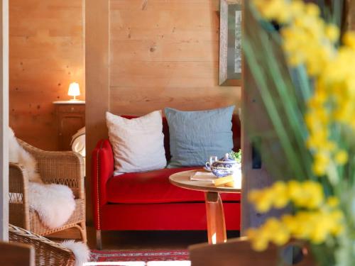 a living room with a red chair and a table at Apartment Chalet Ahorni by Interhome in Hornkessel