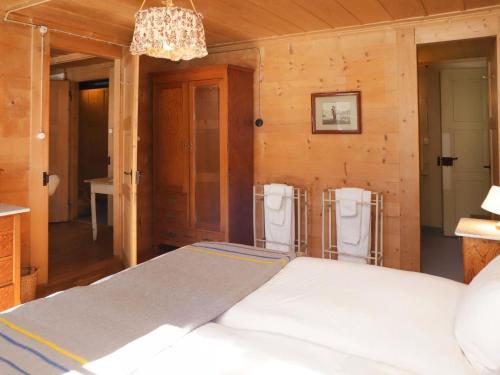 a bedroom with a bed and a chandelier at Apartment Chalet Ahorni by Interhome in Hornkessel