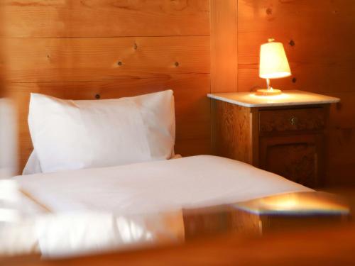 a bedroom with a bed with a lamp on a table at Apartment Chalet Ahorni by Interhome in Hornkessel