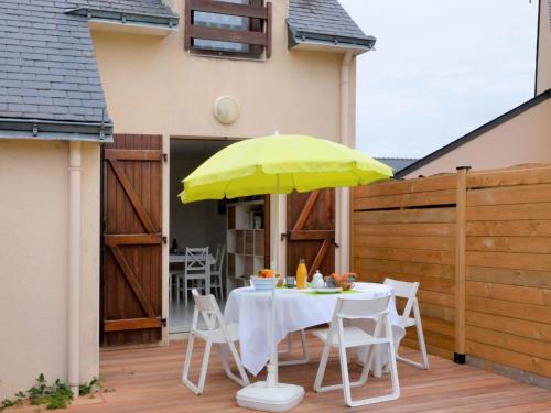 stół z żółtym parasolem na patio w obiekcie Holiday Home La Criée by Interhome w mieście La Turballe