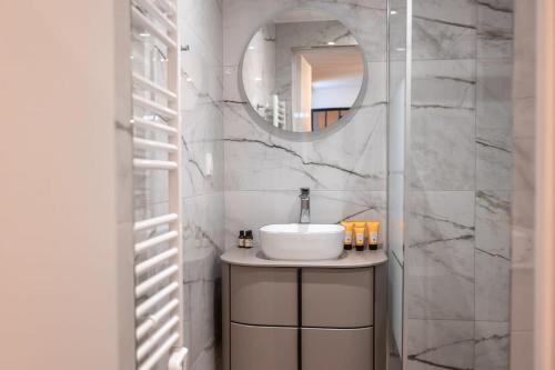 une salle de bain avec un lavabo et un miroir dans l'établissement Rez de chausse dans une rue pavee 4 pers Nation, à Paris