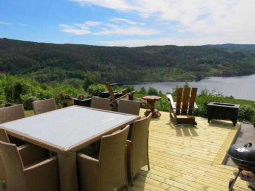 een terras met een tafel en stoelen en uitzicht op een meer bij Holiday Home Trondbu - SOW106 by Interhome in Madland