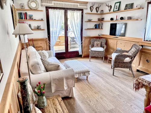 uma sala de estar com um sofá e cadeiras em Apartment Chesa Tschierv II 30 by Interhome em Celerina
