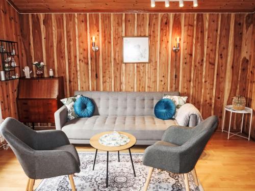 ein Wohnzimmer mit einem Sofa und 2 Stühlen in der Unterkunft Chalet Grønnehytta - FJH606 by Interhome in Gjelland