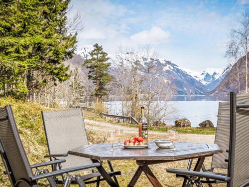 a table with a bowl of fruit and a bottle of wine at Holiday Home Veganeset I - FJS294 by Interhome in Balestrand