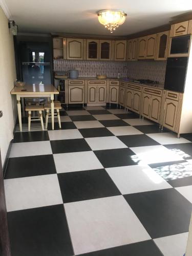 a kitchen with a black and white checkered floor at Lola in Tskaltubo