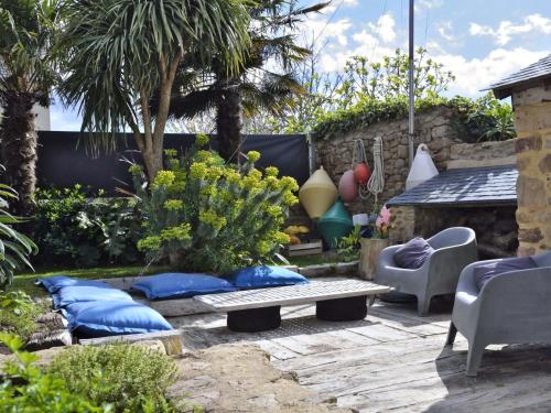 un patio avec des coussins bleus et un banc dans un jardin dans l'établissement Holiday Home La Demeure de Tumiac by Interhome, à Arzon