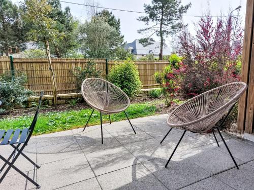 deux chaises assises sur un trottoir à côté d'une clôture dans l'établissement Apartment Hemisphère by Interhome, à Carnac