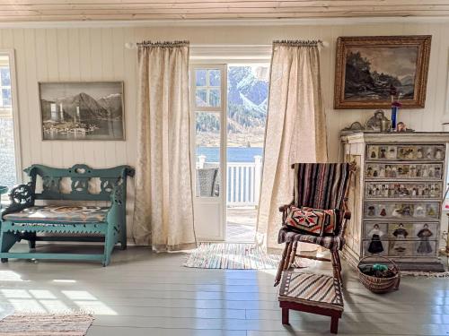 a living room with a green chair and a window at Chalet Villa Esefjord by Interhome in Balestrand